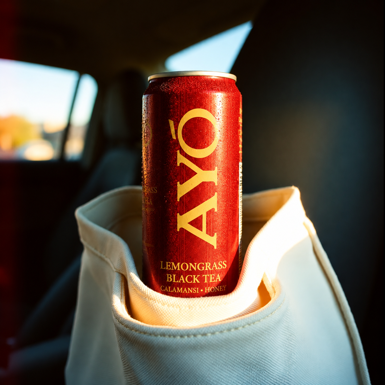 AYÓ Lemongrass Black Tea can tucked into a canvas tote at golden hour