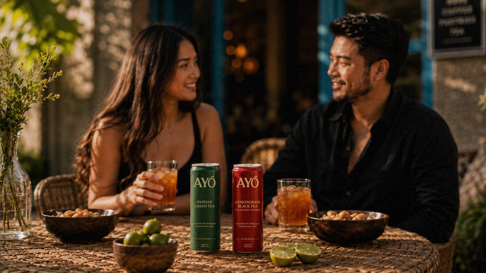 A couple sharing AYÓ at an outdoor table at dusk